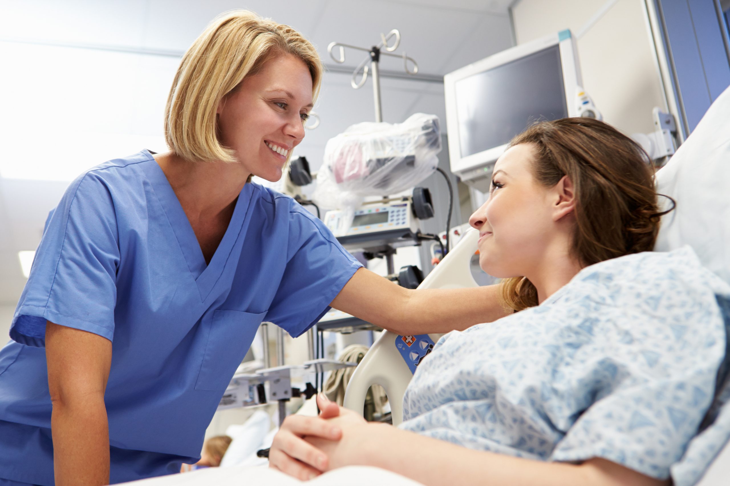 A nurse checks on her college student patient in the hospital.